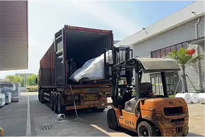 Forklift loading equipment into shipping container